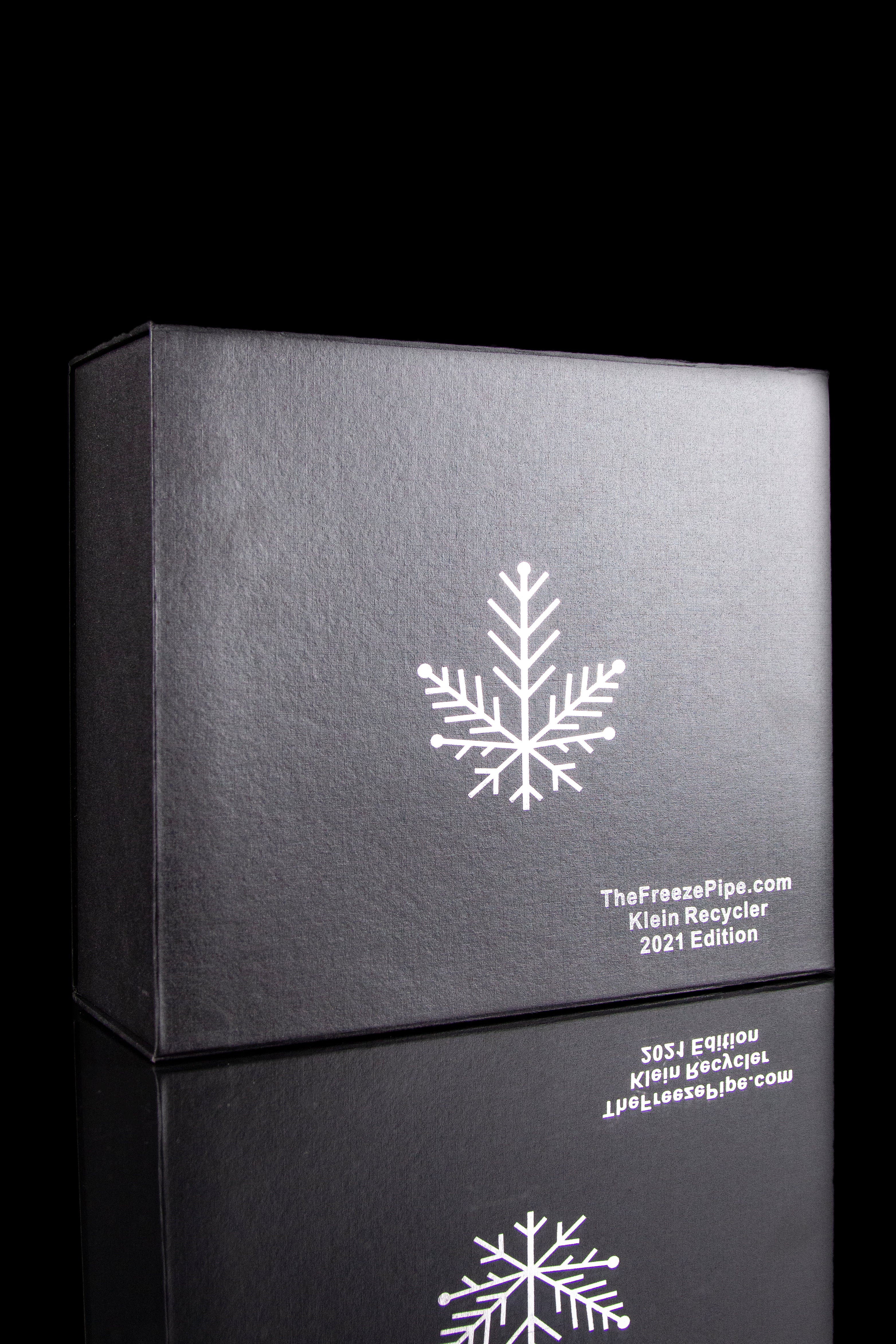 Black boxes stacked with a white snowflake design and branding for "TheFreezePipe.com" and a "Klein Recycler 2021 Edition" cannabis accessory.