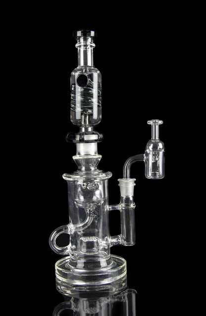 Clear glass water pipe (rig) with multiple chambers and a separate oil dome, isolated on a black background.