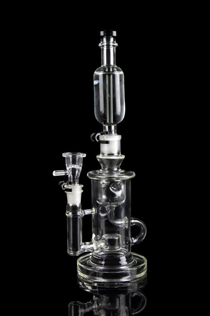 Clear glass water pipe (rig) with multiple chambers and attachments, isolated on a black background.