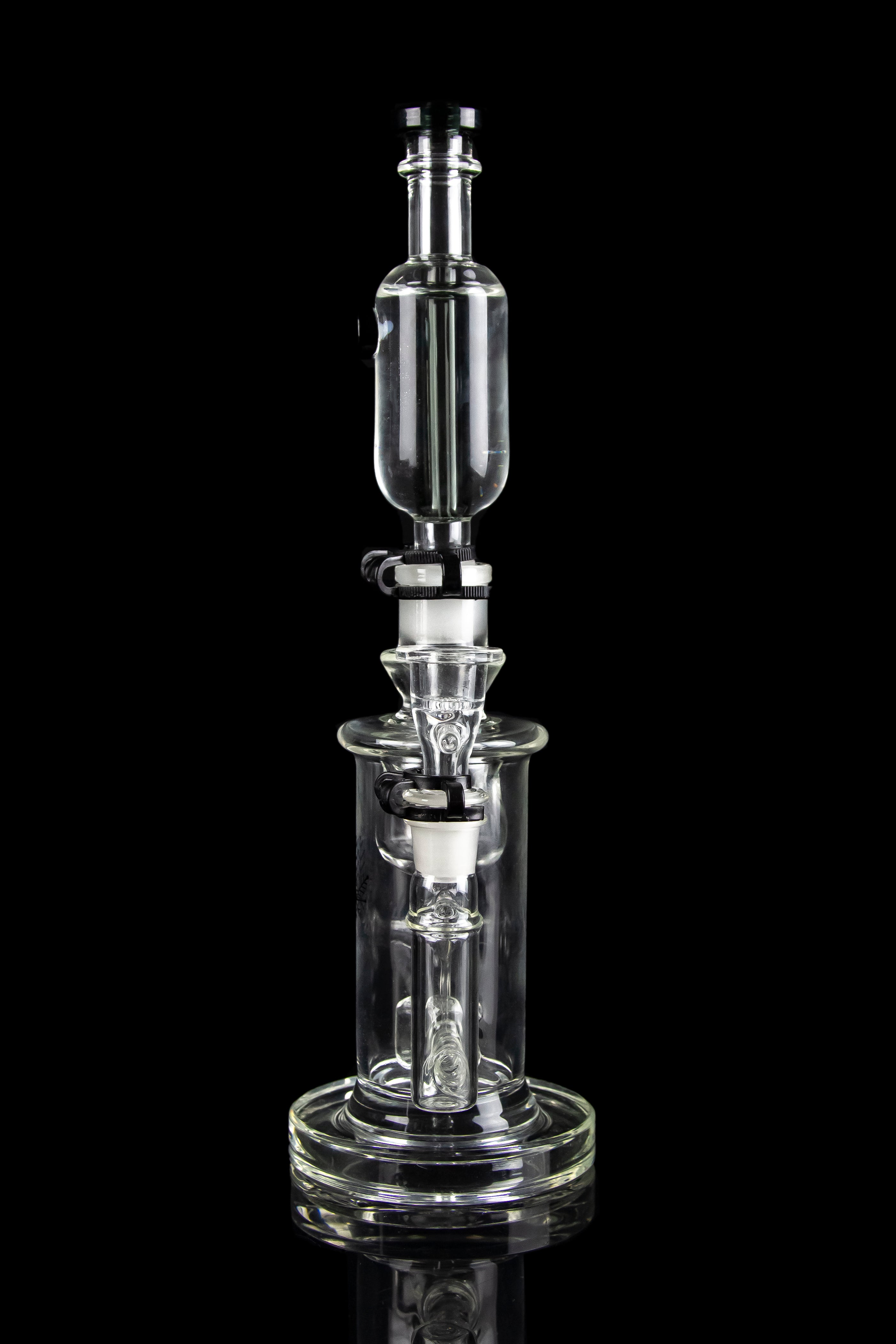 Clear glass dab rig with intricate percolator chambers, isolated on a black background.