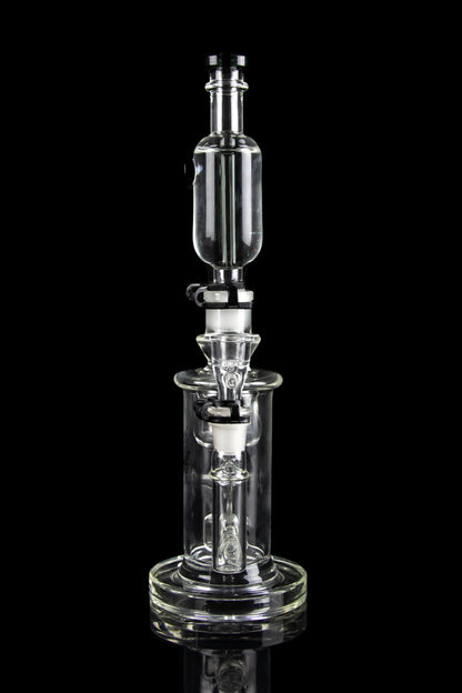 Clear glass dab rig with intricate percolator chambers, isolated on a black background.