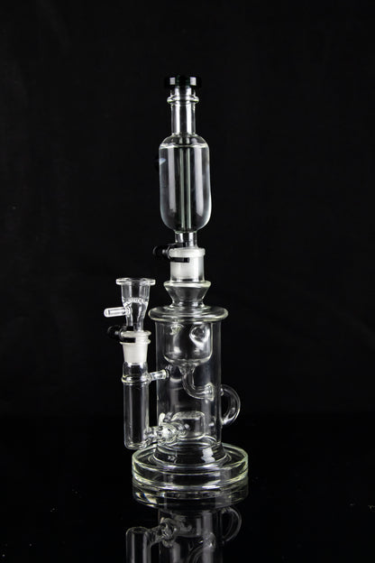 Clear glass water pipe (rig) with multiple chambers and a glass bowl, isolated on black.