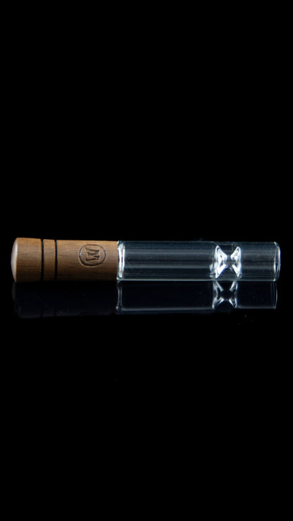 Wooden-tipped glass chillum with visible flower inside, against a black background.