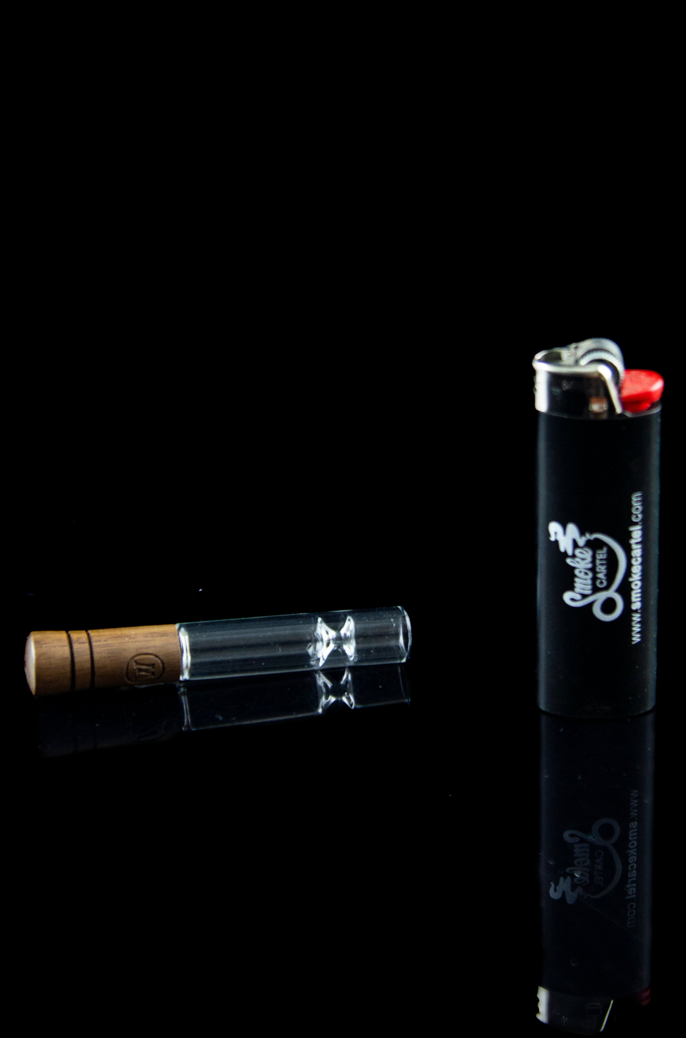 Glass oil burner pipe and lighter on a black background.