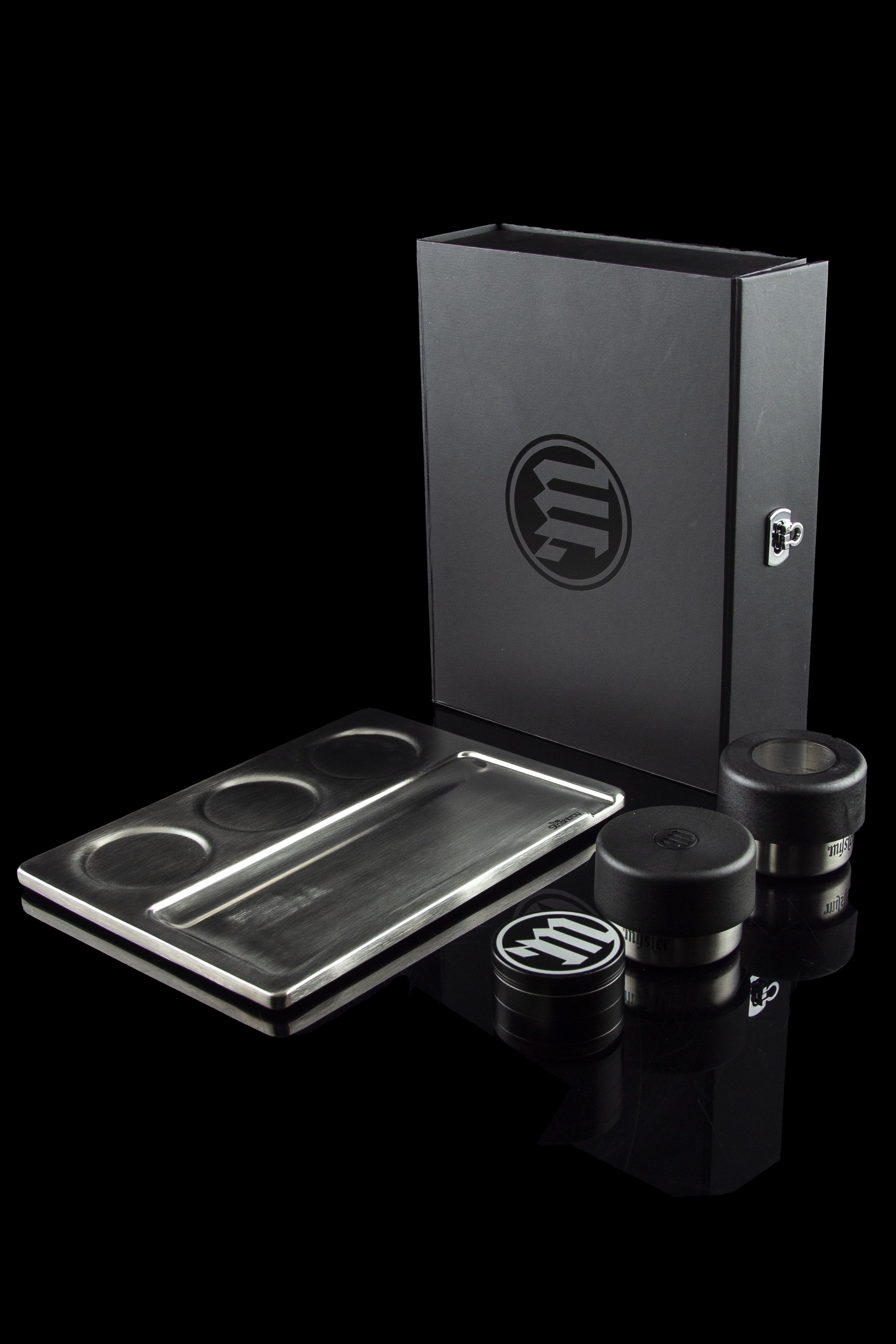 Sleek black cannabis storage box with rolling tray and jars, branded with a circular “m” logo.