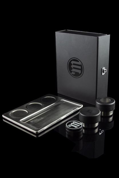 Sleek black cannabis storage box with rolling tray and jars, branded with a circular “m” logo.