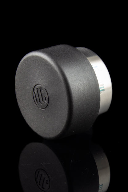 Black cannabis oil concentrate container with reflective surface, featuring a branded logo.