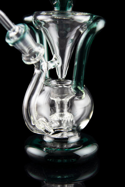 Clear glass water pipe (rig) with intricate bubbler design, isolated on black.