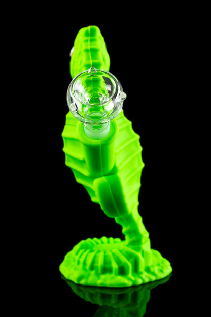 Glowing green glass seahorse-shaped dab rig with a glass orb.