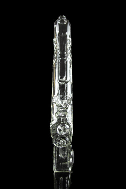 Clear glass bubbler with intricate sculpted design, reflected on a black surface.