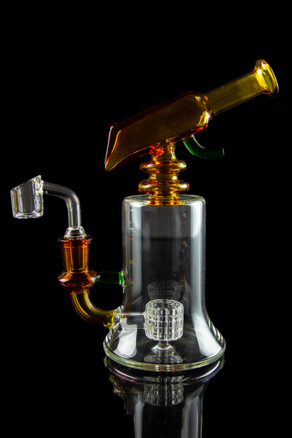 A clear glass dab rig with orange accents, featuring a perc diffuser and separate nail, isolated on a black background.
