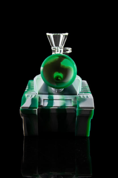 A glass cannabis water pipe, illuminated with green and white light, against a black background.
