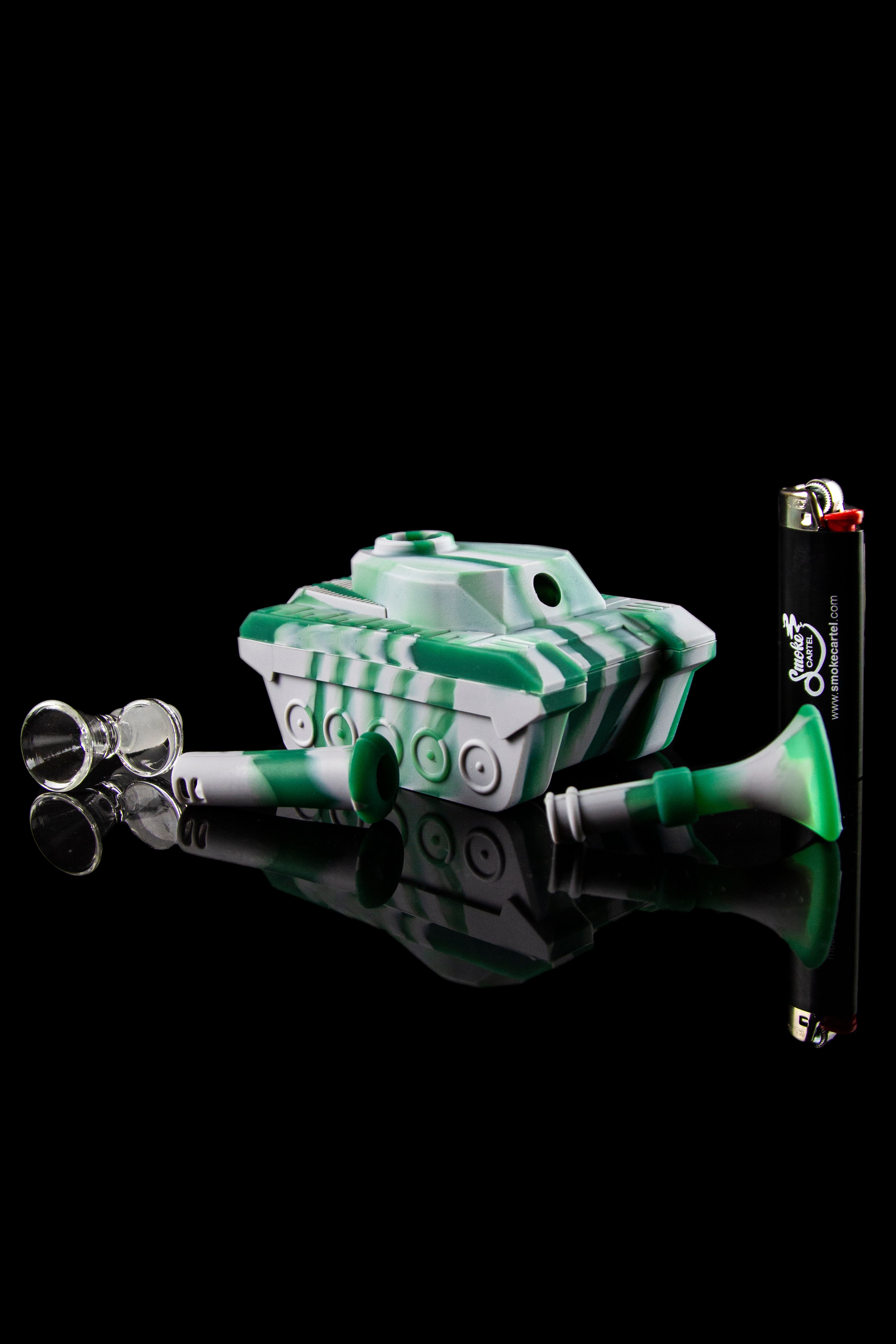 Green and white glass water pipe with accompanying glass bubbles and lighter, isolated on a black background.