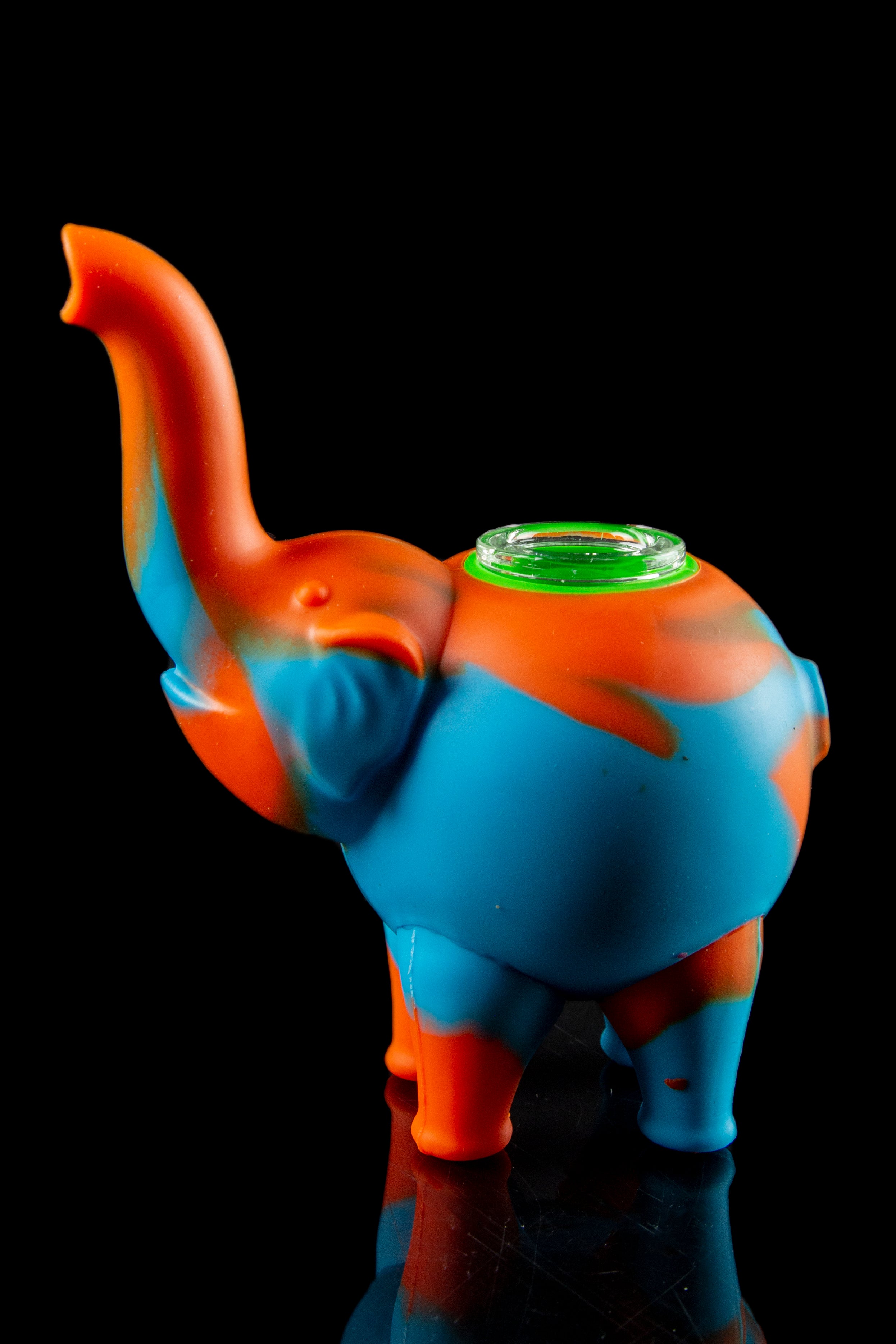 Blue and orange silicone elephant-shaped water pipe with a glass bowl, studio shot on a reflective surface.