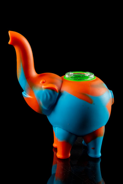 Blue and orange silicone elephant-shaped water pipe with a glass bowl, studio shot on a reflective surface.