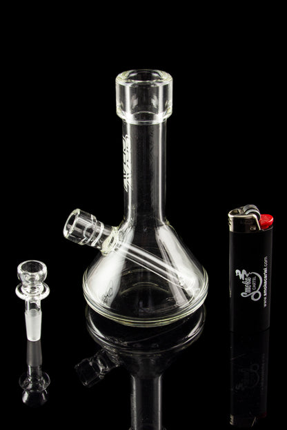 Clear glass bong with a detachable downstem and bowl, alongside a lighter, against a black background.