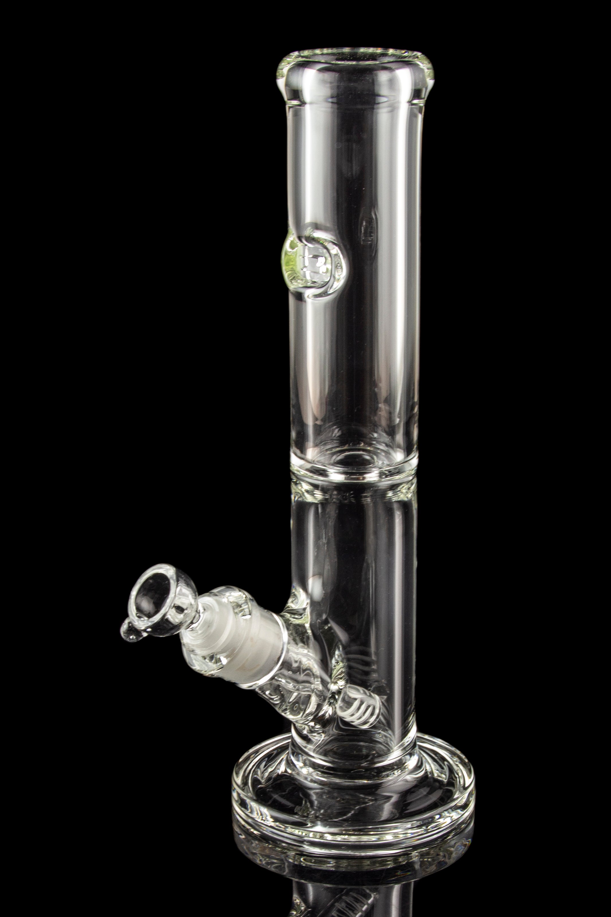 Clear glass water pipe (bong) with a flared base and ice catch, reflecting on a black surface.