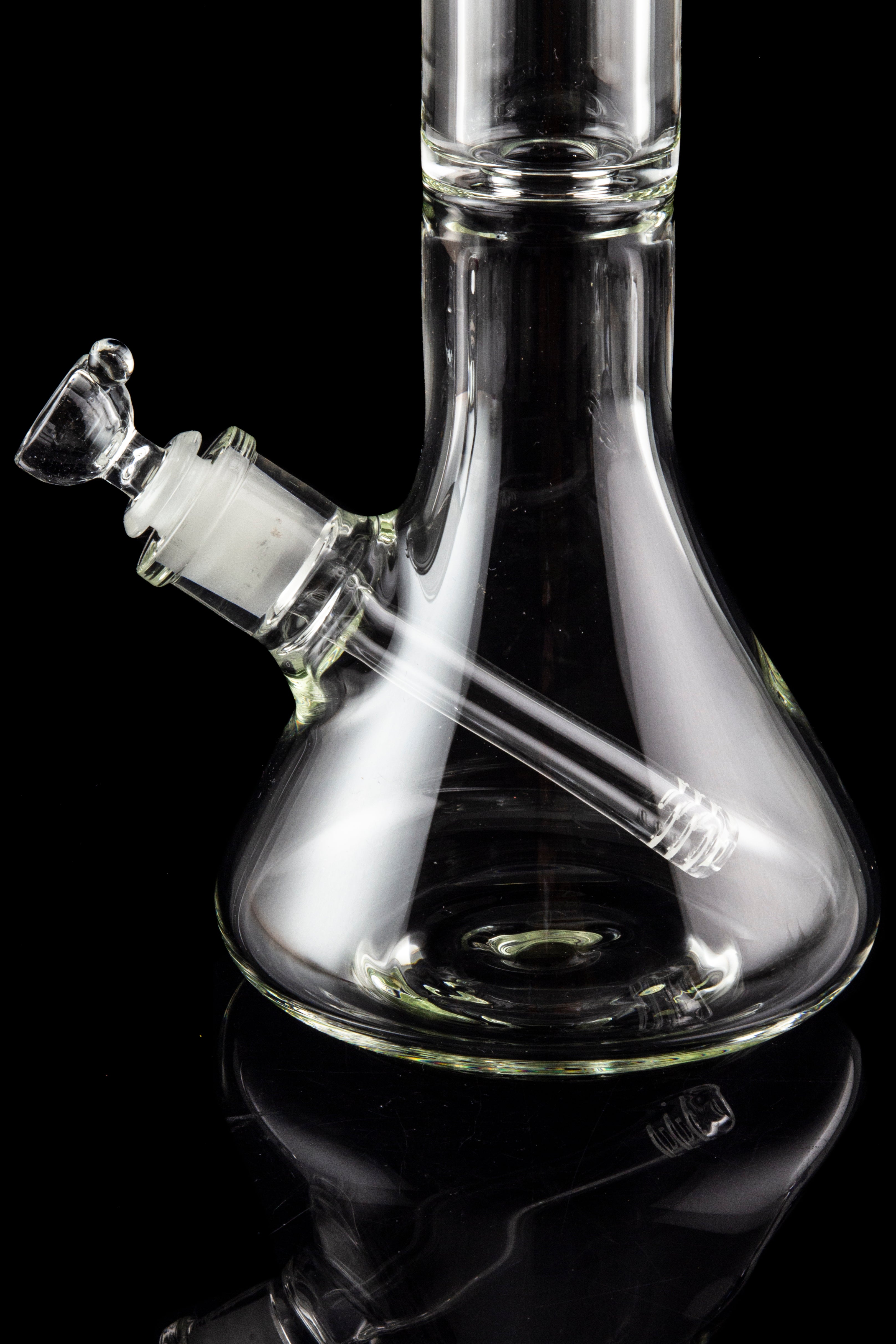 Clear glass bong with a flared base and angled neck, isolated on a black background.