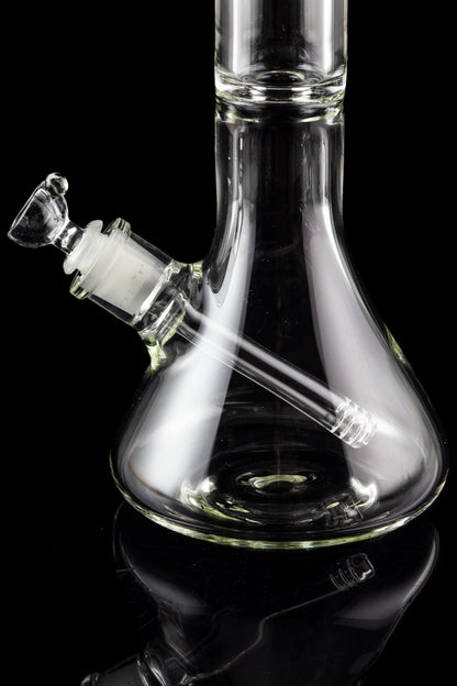 Clear glass bong with a flared base and angled neck, isolated on a black background.