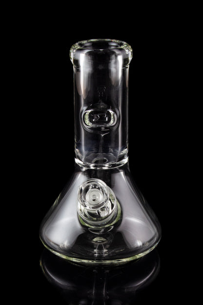Clear glass bong with a flared base and bubble percolator, isolated on a black reflective surface.