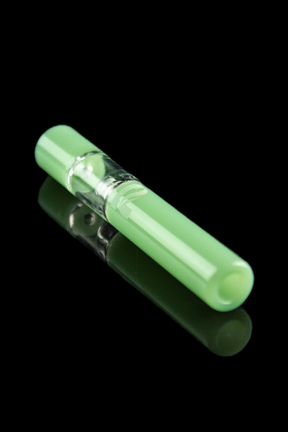Green glass chillum with a visible chamber, reflecting on a black surface.