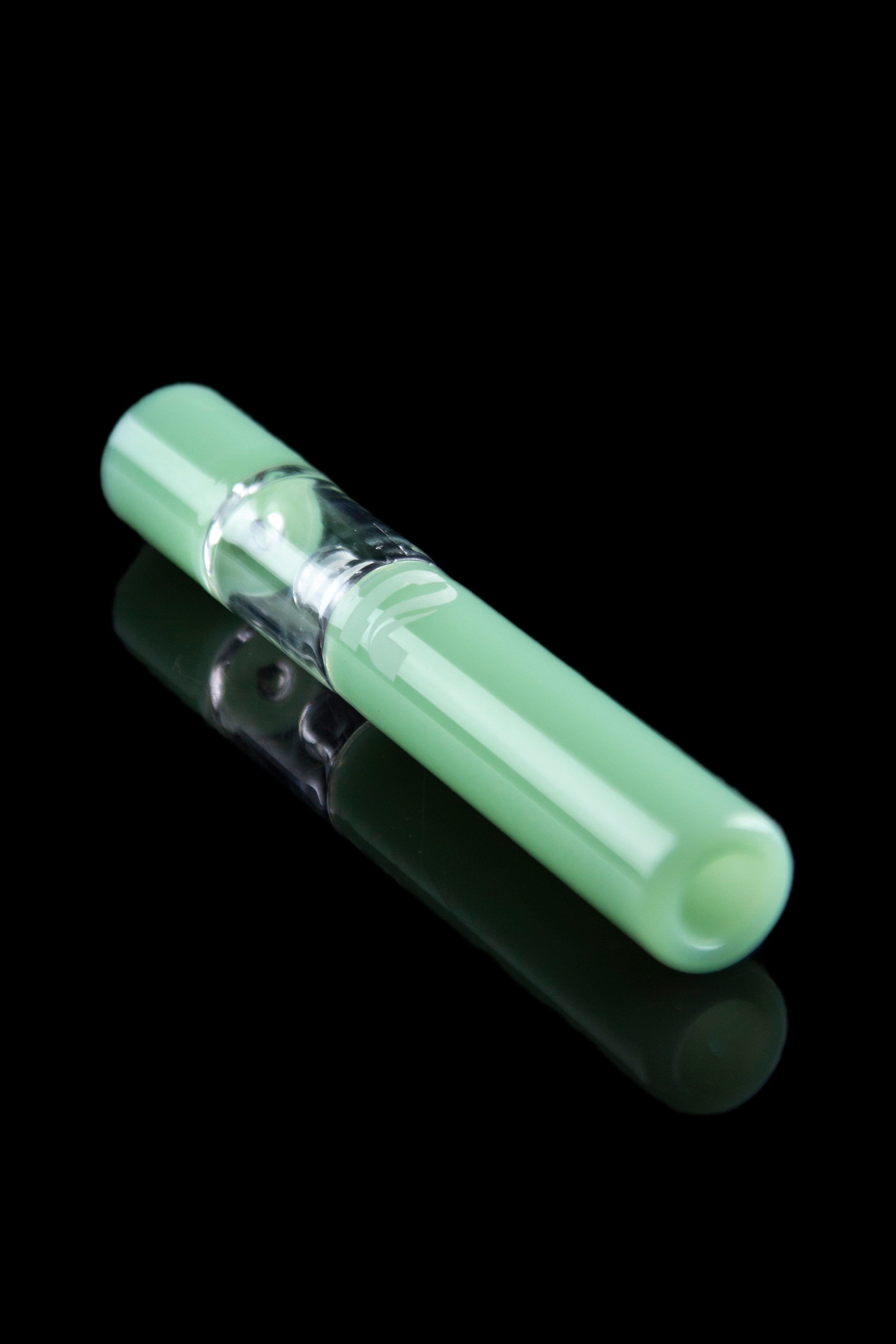Frosted green glass chillum with visible chamber, reflecting on a dark surface.