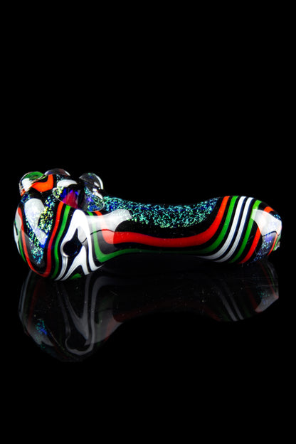Colorful glass cannabis pipe with iridescent glitter accents, displayed on a reflective black surface.