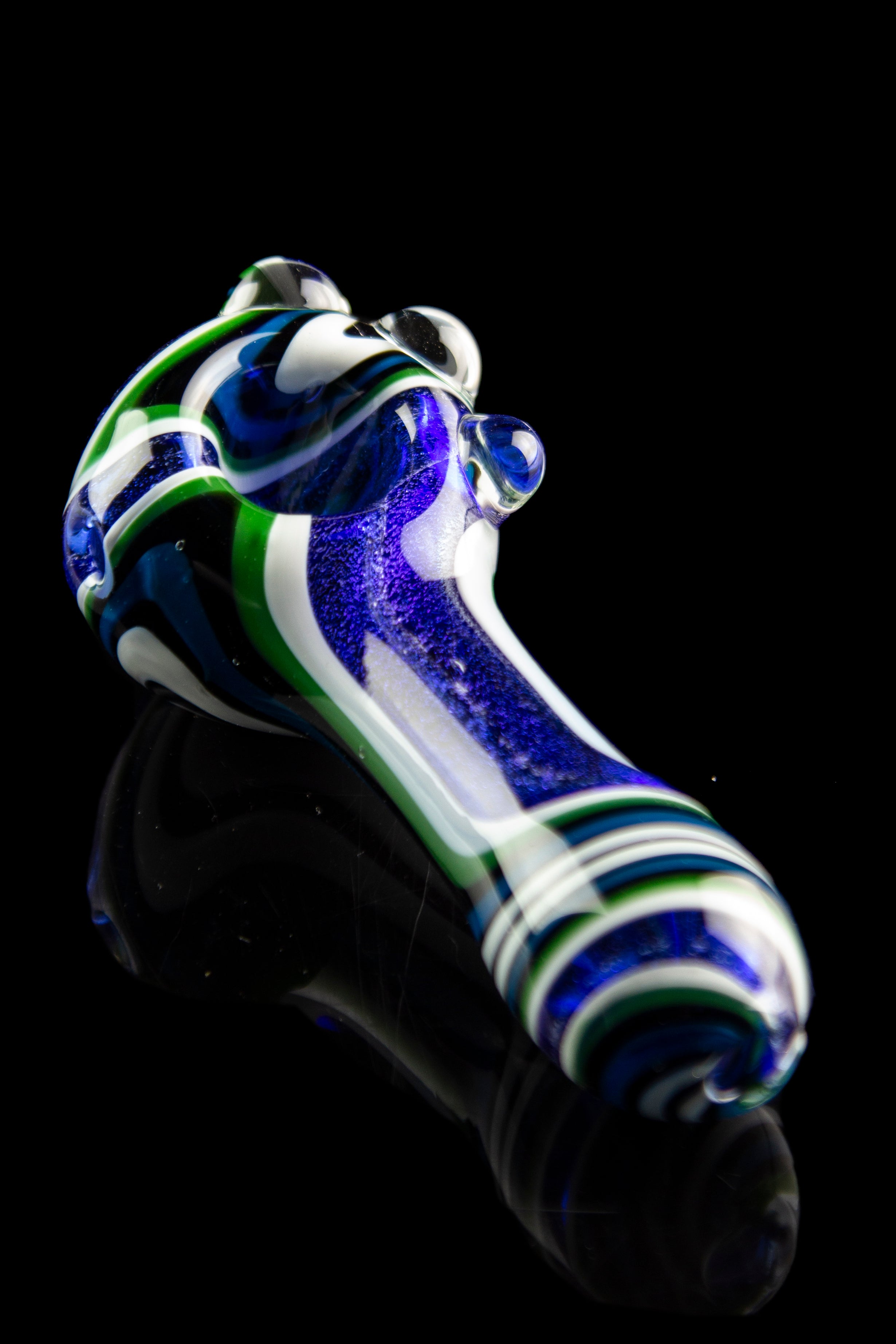 Hand-blown glass pipe with blue, white, and green swirl pattern against a black reflective surface.