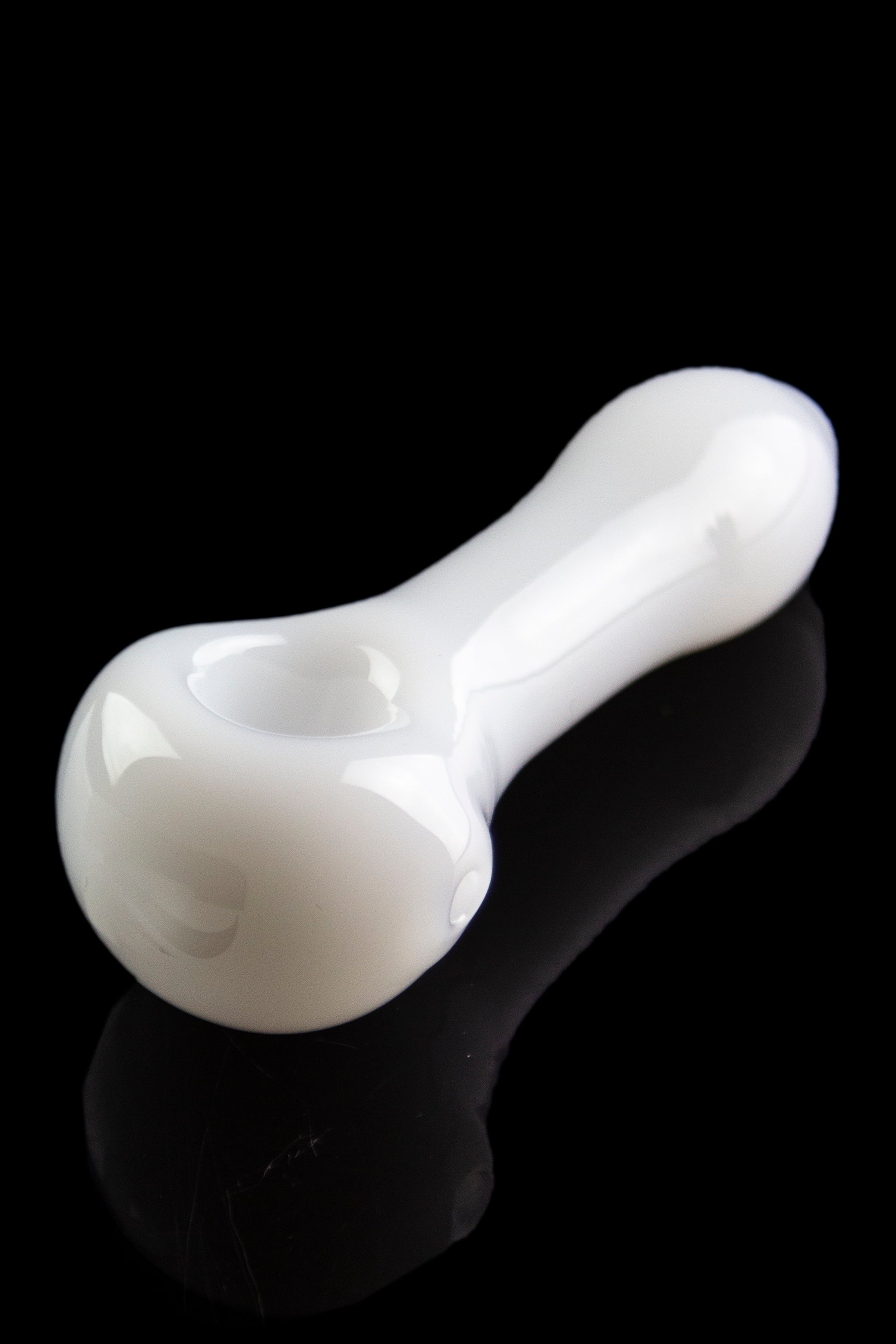 White glass pipe with a glossy finish, reflecting on a dark surface.
