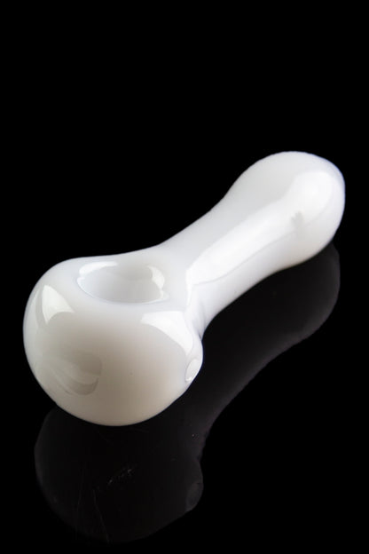White glass pipe with a glossy finish, reflecting on a dark surface.