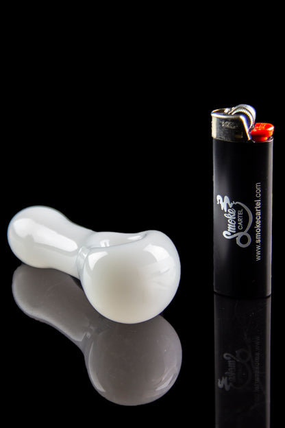 White glass pipe and lighter with “Smoke Cartel” branding, reflected on a glossy black surface.