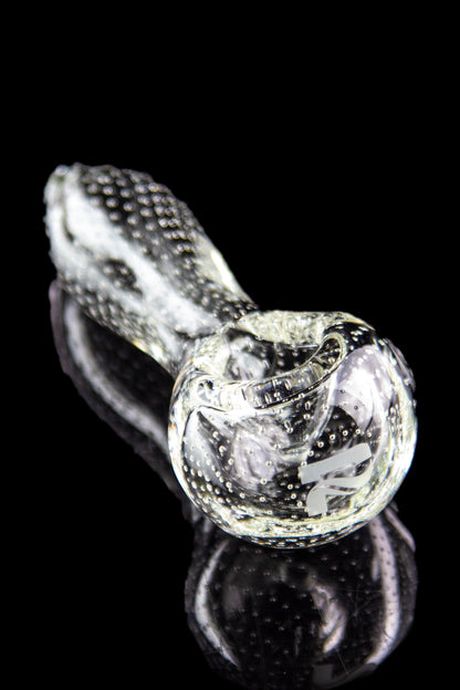 Clear glass pipe with textured surface and reflective black background.