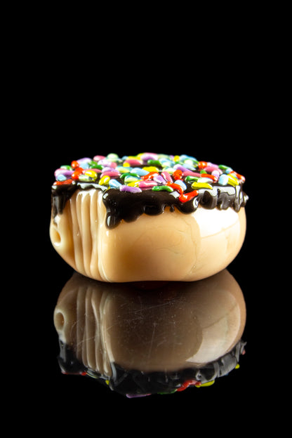 Glass pipe shaped like a sprinkled donut with a glossy black reflection.