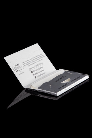 Pack of Randy's rolling papers and plastic rolling tool on a reflective surface. - Randy's Classic Wired Rolling Papers