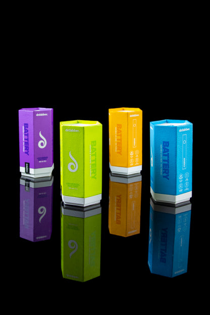 Colorful cannabis vape battery packaging stacked on a reflective surface.