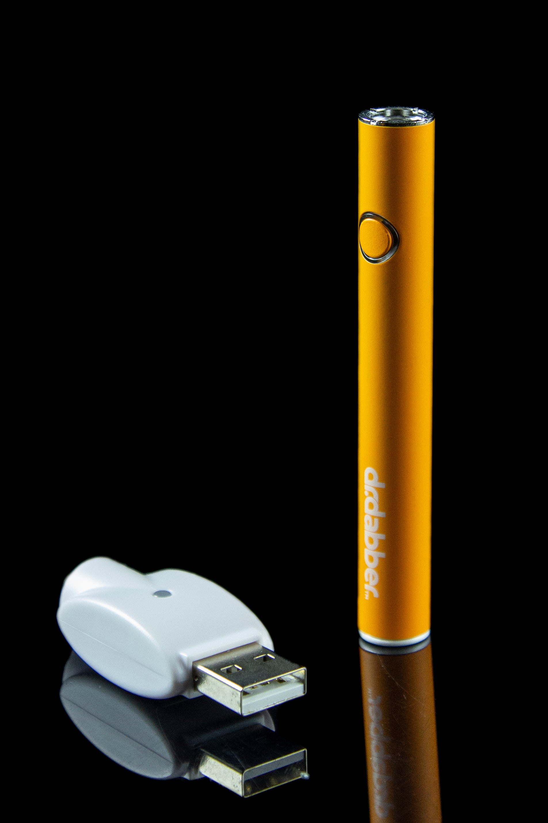 Orange cannabis vape pen and USB charger on a reflective surface.