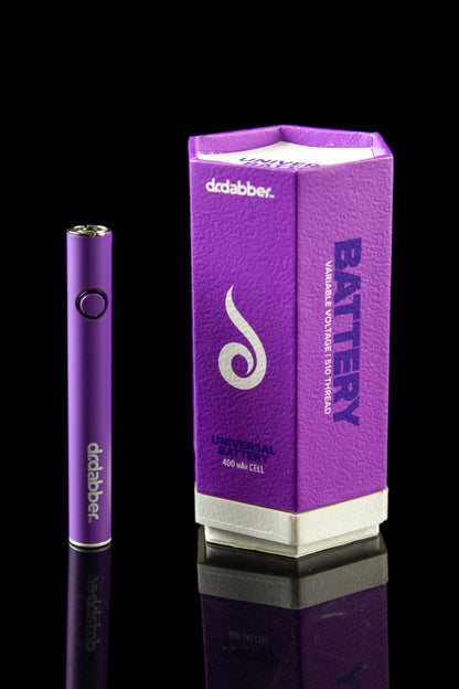 Purple Dr. Dabber battery and packaging, reflecting on a glossy surface.