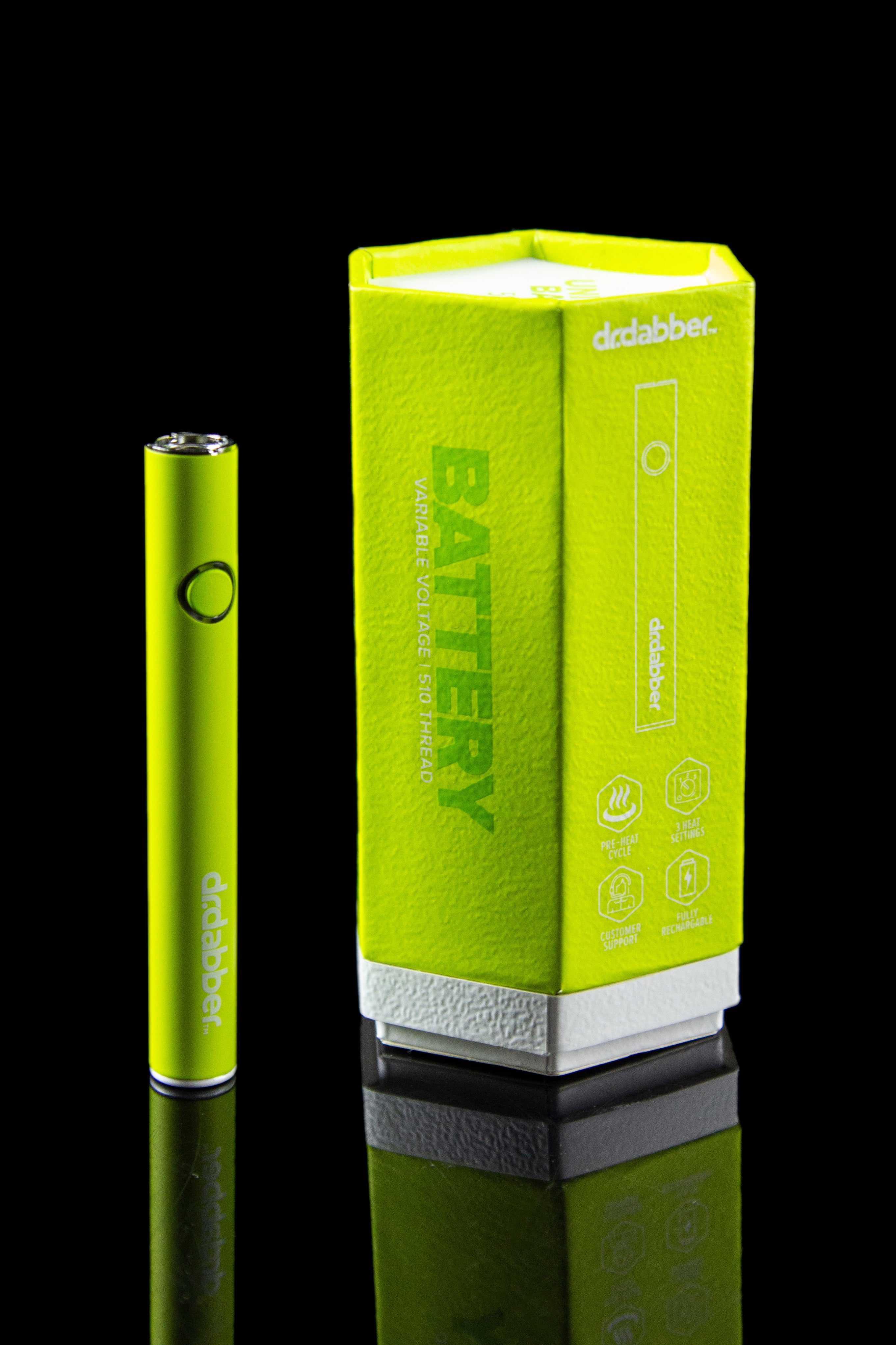 Green Dr. Dabber battery and packaging with branding, reflecting on a glossy black surface.