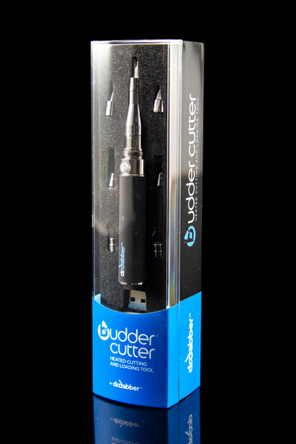 A sleek, angled studio shot of the Dr. Dabber Budder Cutter against a dark, reflective surface.