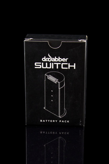Black packaging for a “Dr. Dabber Switch” battery pack, featuring a line drawing of the device.