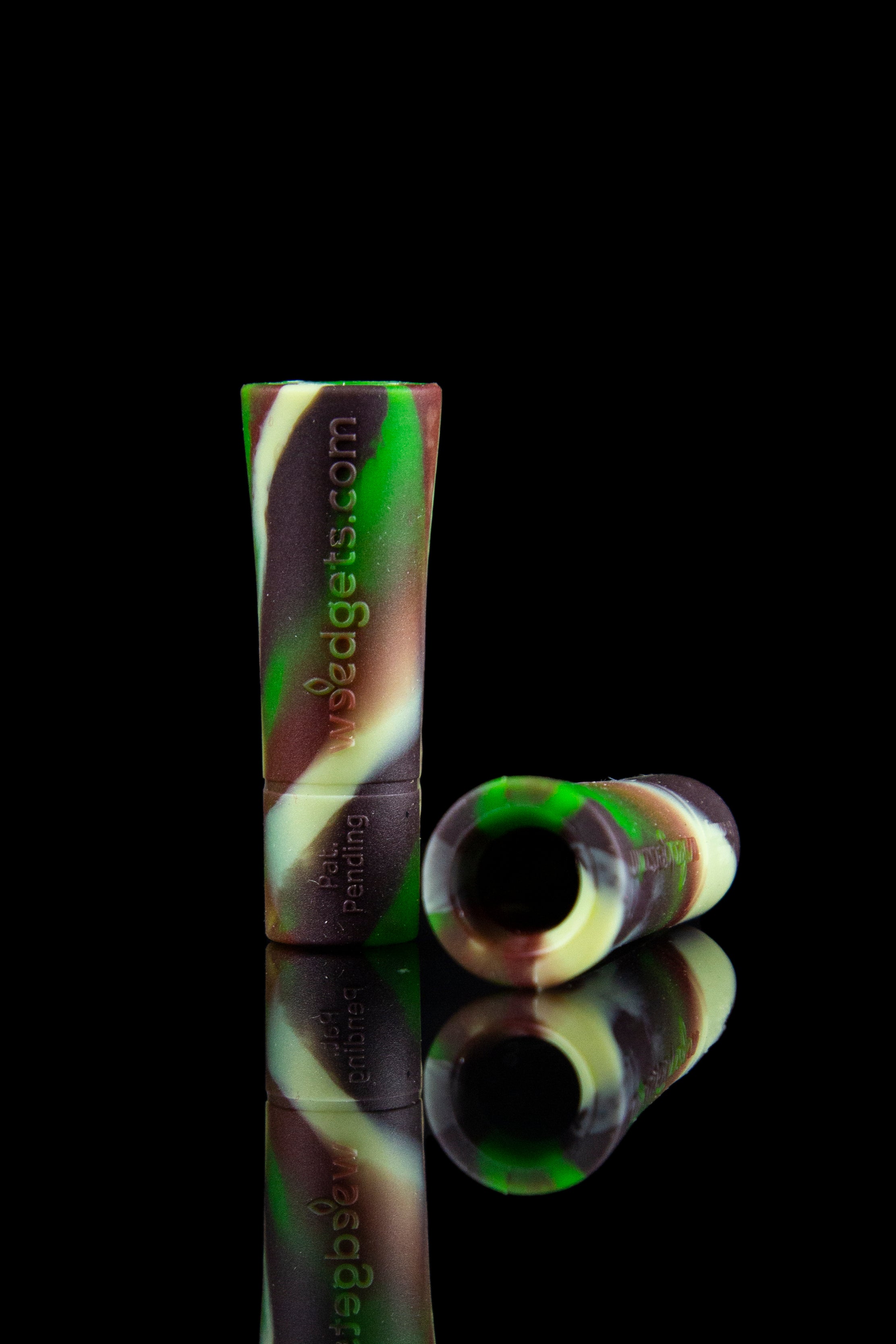 Green and maroon silicone oil rig with a glass bowl, reflected on a black surface.