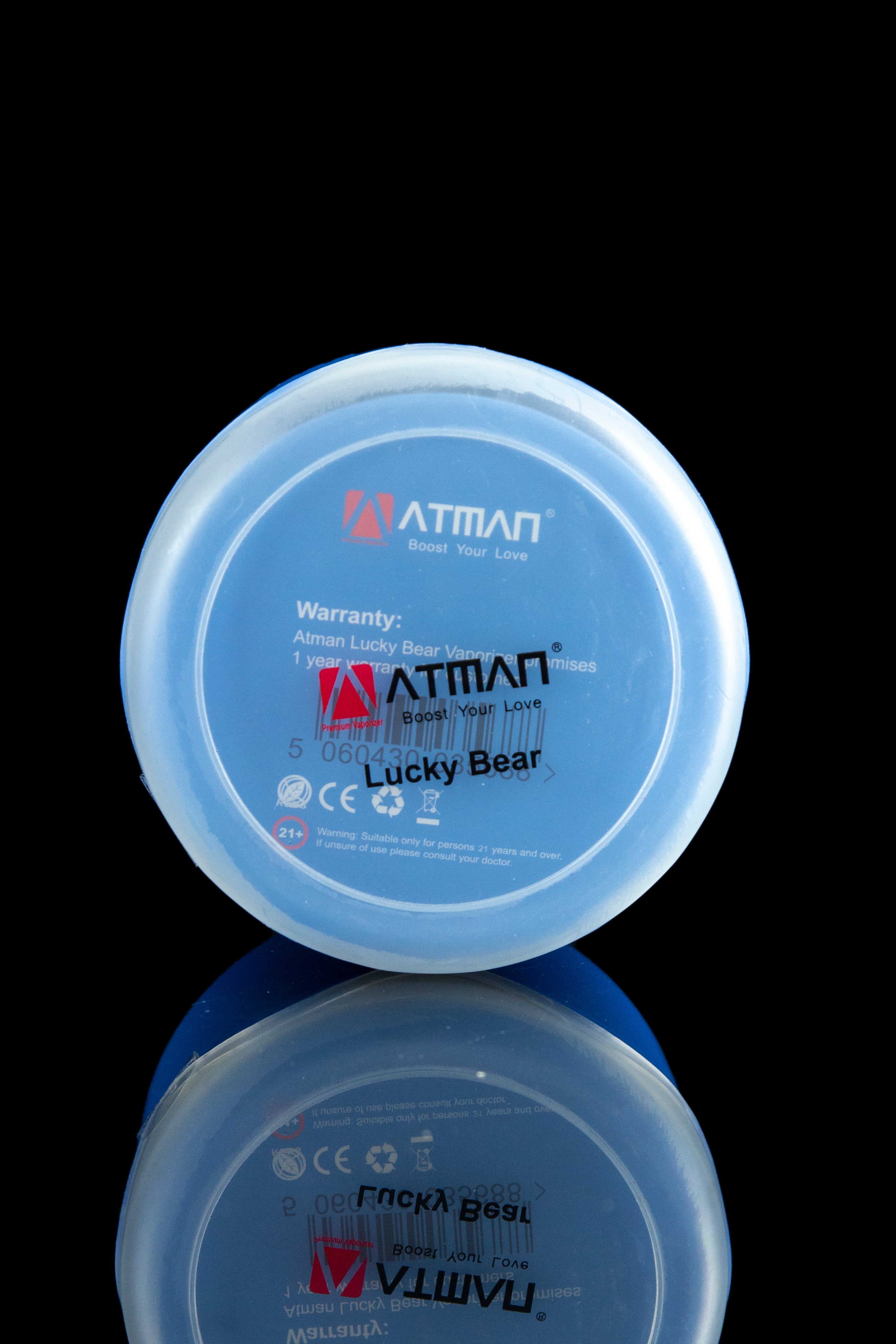 Close-up of a blue “Lucky Bear” cannabis vape cartridge cap with branding and age restriction warning, reflected on a glossy surface.