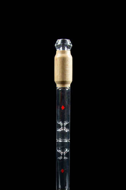 Clear glass cannabis oil burner pipe with gold accents and red detailing, isolated on black.