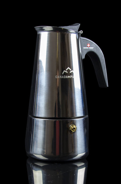 Silver stovetop espresso maker with “Canada PU” etched on the side, reflecting red and white light.