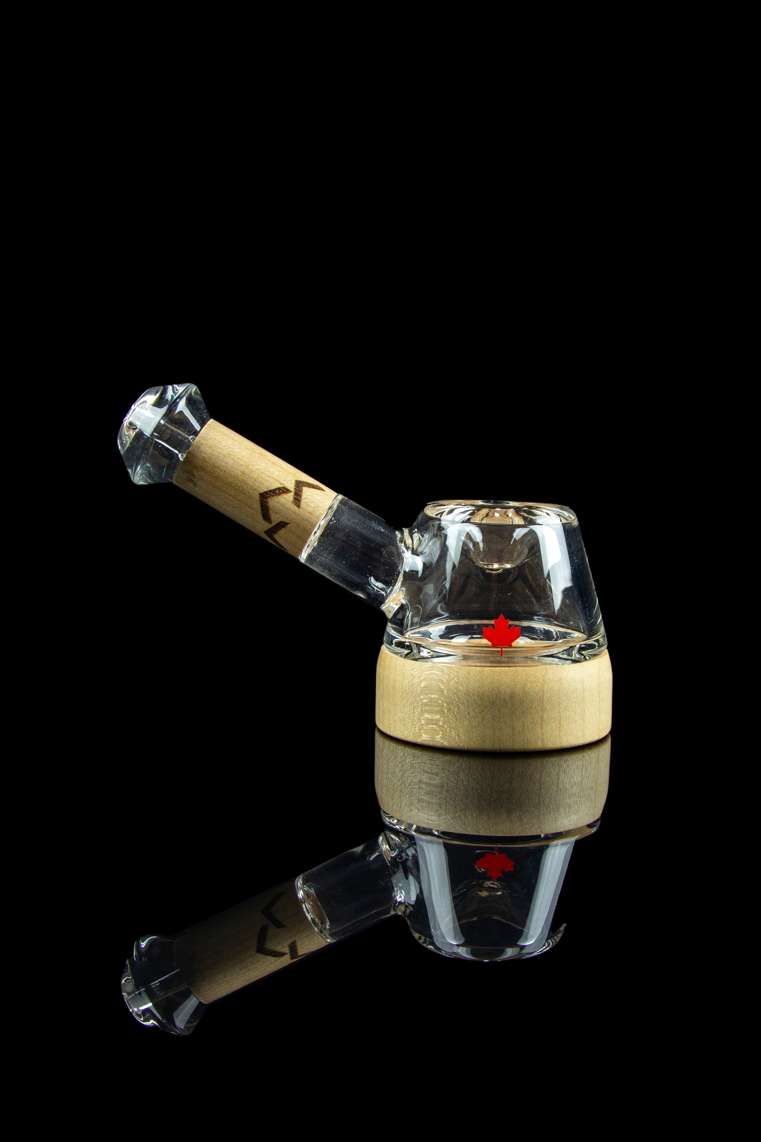 Glass cannabis dab rig with a wooden accent and reflective surface.