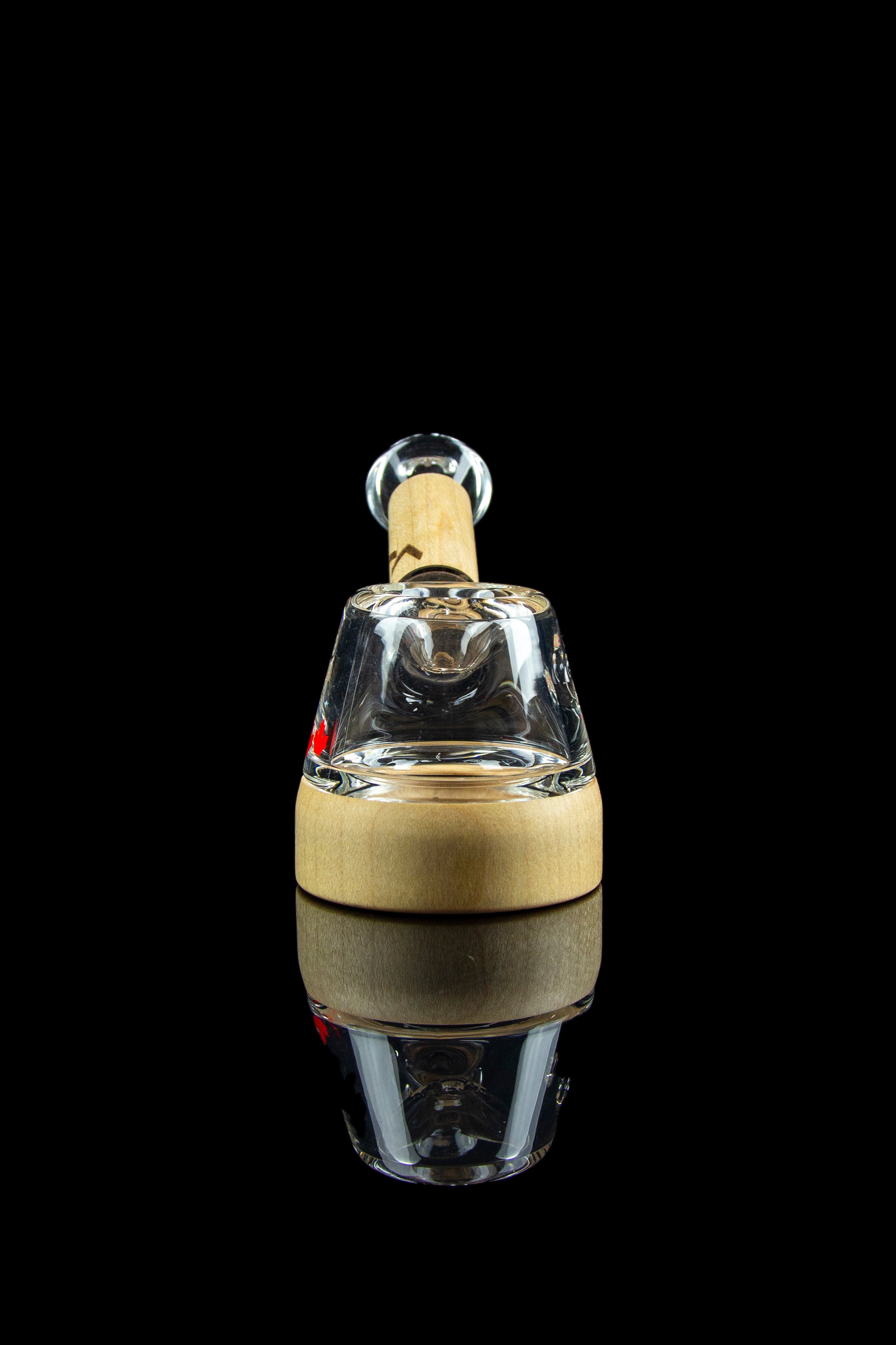 Glass rig for dabbing cannabis, studio shot on a reflective surface.