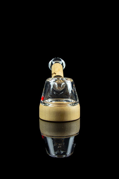 Glass rig for dabbing cannabis, studio shot on a reflective surface.