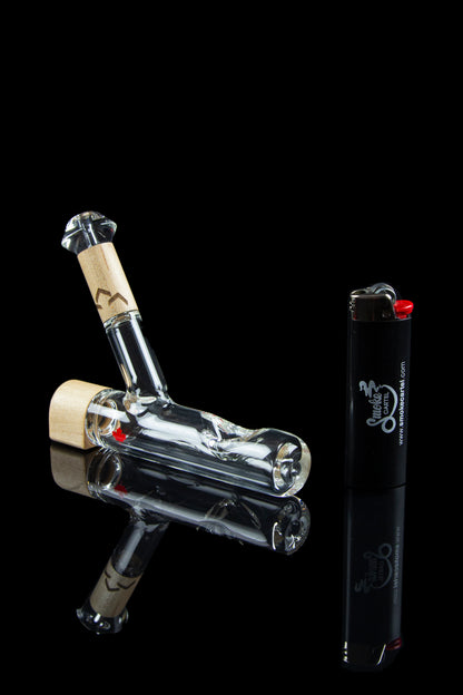 Glass bubbler water pipe and lighter on a dark background.