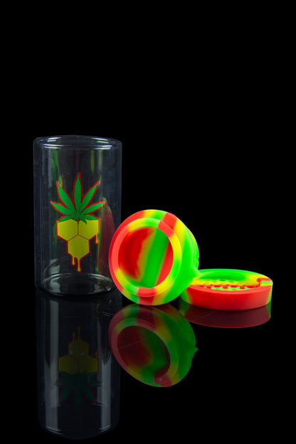 Cannabis storage jar and silicone container with a marijuana leaf design, displayed on a reflective black surface.