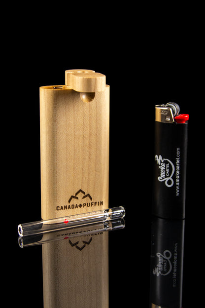 Glass bubbler pipe inside a black carrying case next to a lighter, branded with “Canada Puffin” and “Smoke Cartel.”